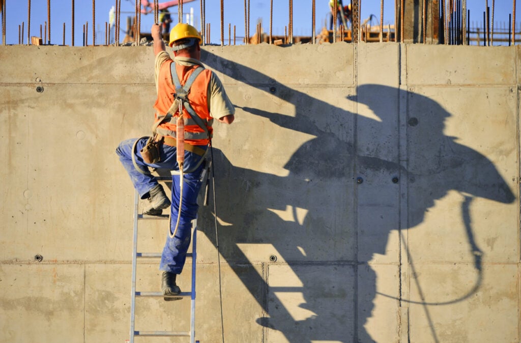 Trabajador con escalera en construcción