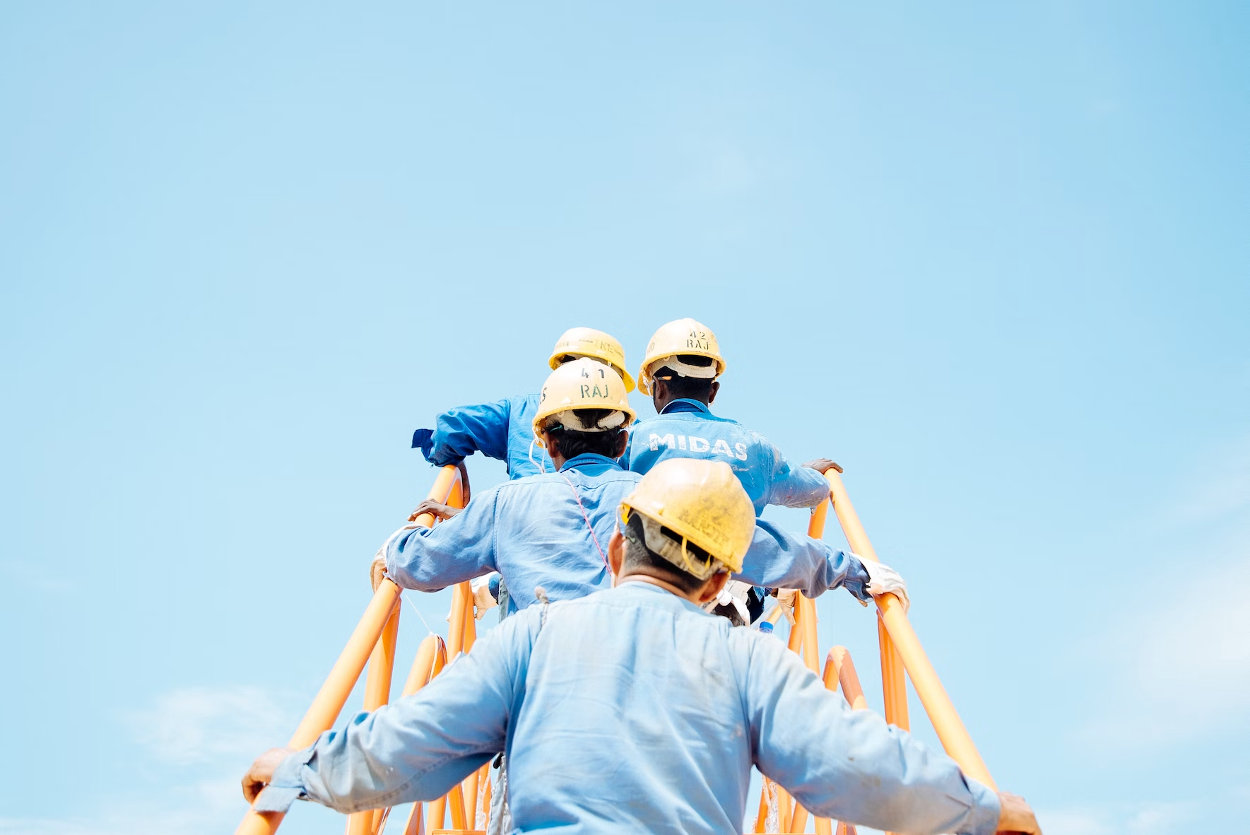 beneficios-curso-osha Trabajadores subiendo escalera en la construcción